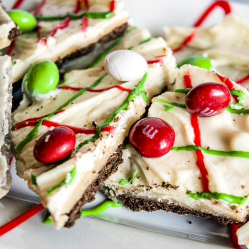 Chocolate graham crackers, with melted white chocolate on top, and swirls of red and green frosting, topped with holiday red, white, and green M&M candies.