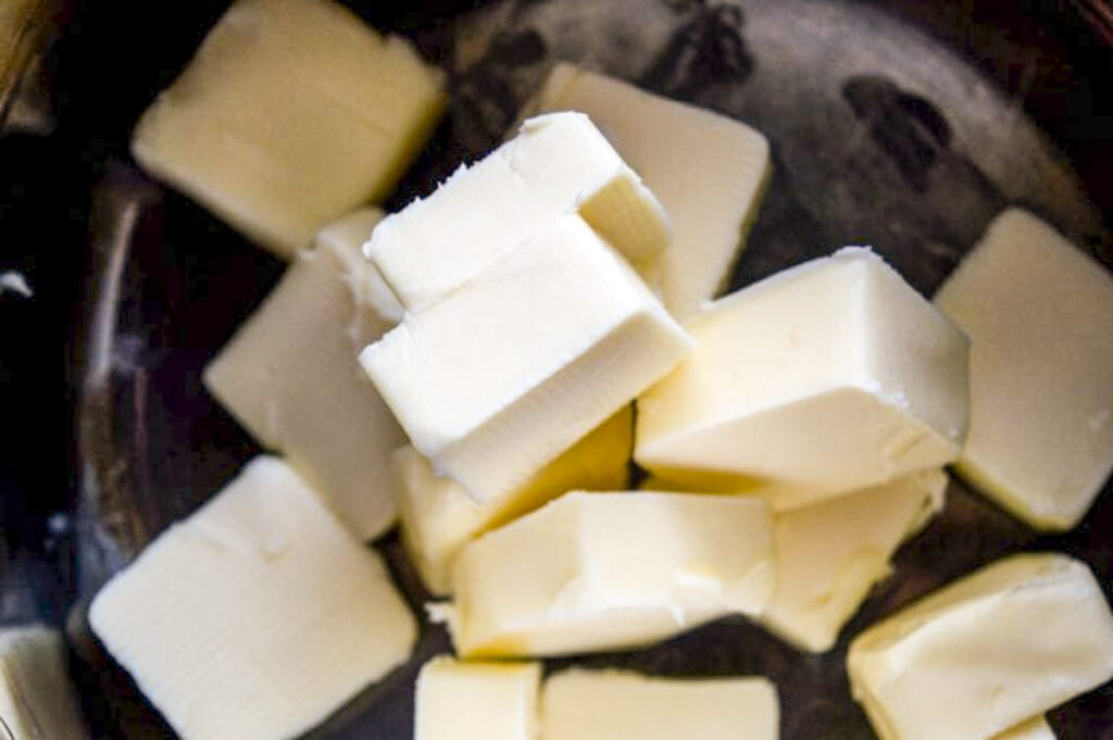 There is cubed butter in a pot to melt for toffee.