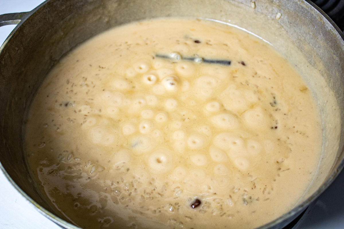 Bubbles are rising in the pot of rice pudding.
