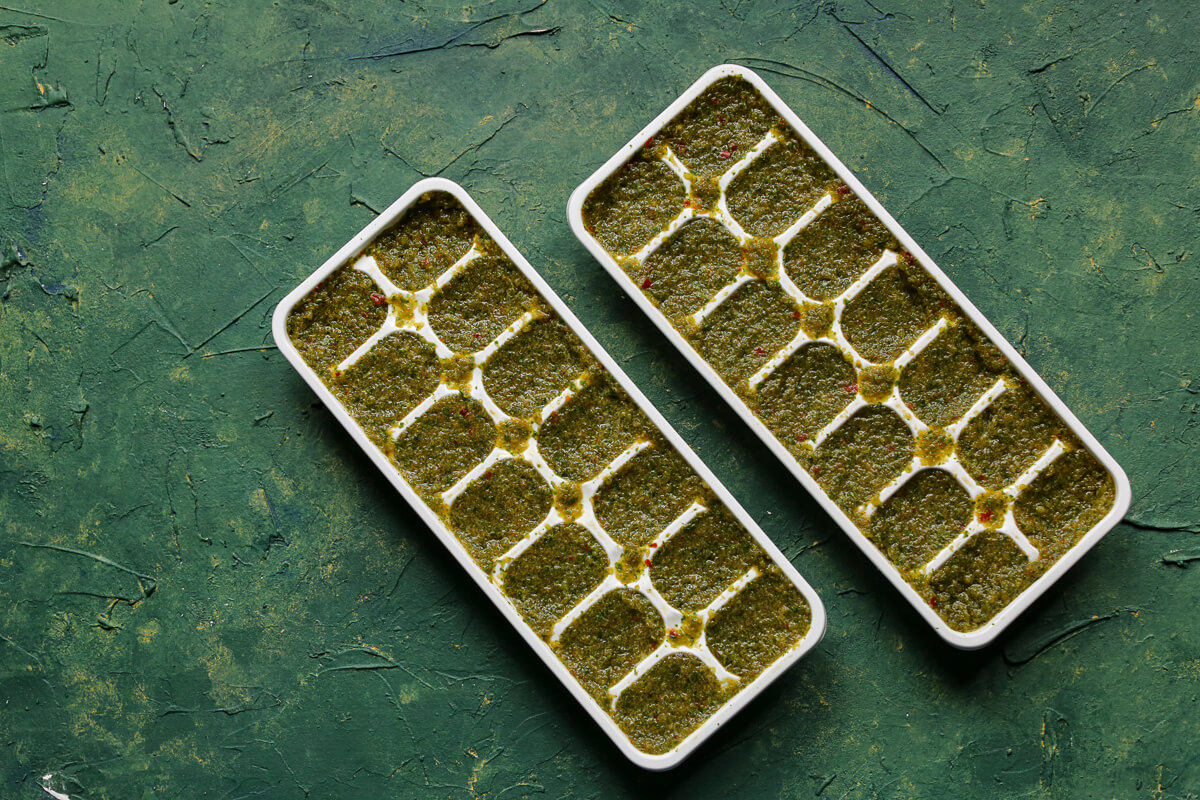 Two ice cube trays with a green background.