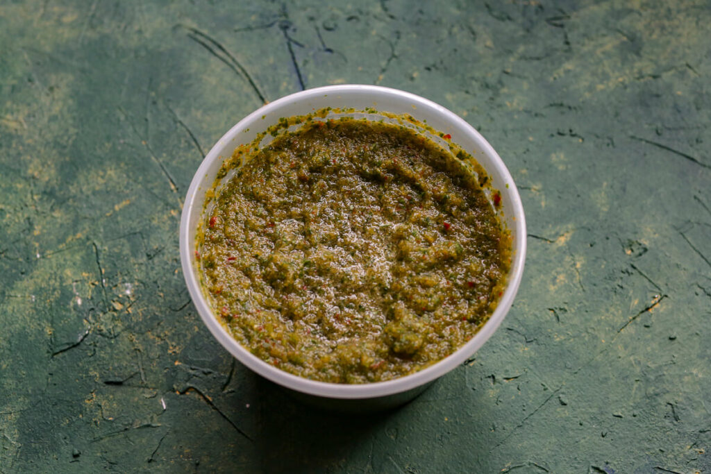 A small plastic container is storing sofrito